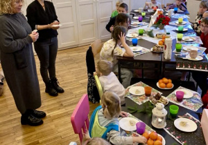 Pani dyrektor i wychowawczyni z opłatkami w dłoniach podczas wigilii klasowej z dziećmi.